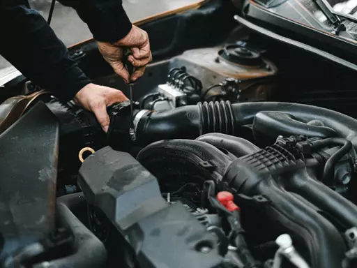 Profissional realizando reparos no motor de um veículo automotor.