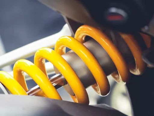 Detalhe da suspensão, amortecedor e molas de um veículo automotor.